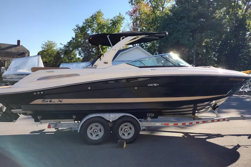 Slide: The Image of 2014 Sea Ray 270 SLX boat on trailer, parked outdoors with trees in background. - 5