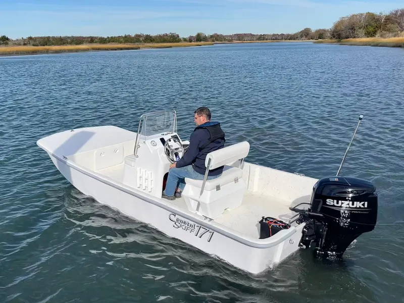 Slide: The Image of 2025 Coastal Skiff 171 boat with Suzuki motor on calm water. - 5