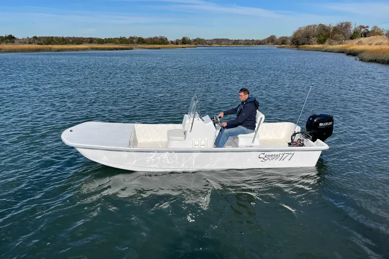 Slide: The Image of 2025 Coastal Skiff 171 boat on calm water with driver. - 7