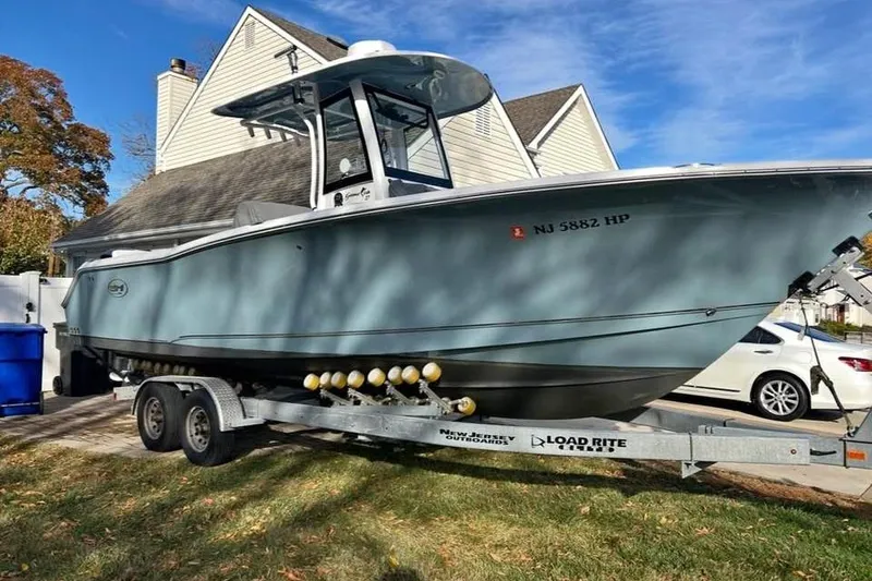 The Image of 2021 Sea Hunt Gamefish 27 Coffin Box boat on trailer in residential driveway. - 0