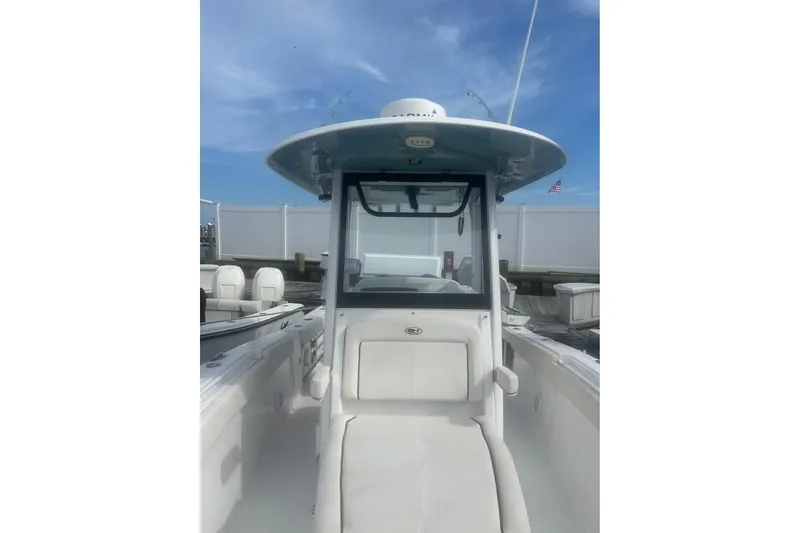 Slide: The Image of 2021 Sea Hunt Gamefish 27 Coffin Box boat, center console view, docked under blue sky. - 10