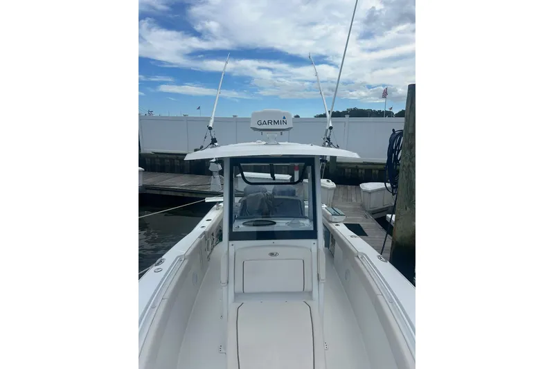 Slide: The Image of 2021 Sea Hunt Gamefish 27 Coffin Box boat docked, featuring Garmin equipment under a cloudy sky. - 11