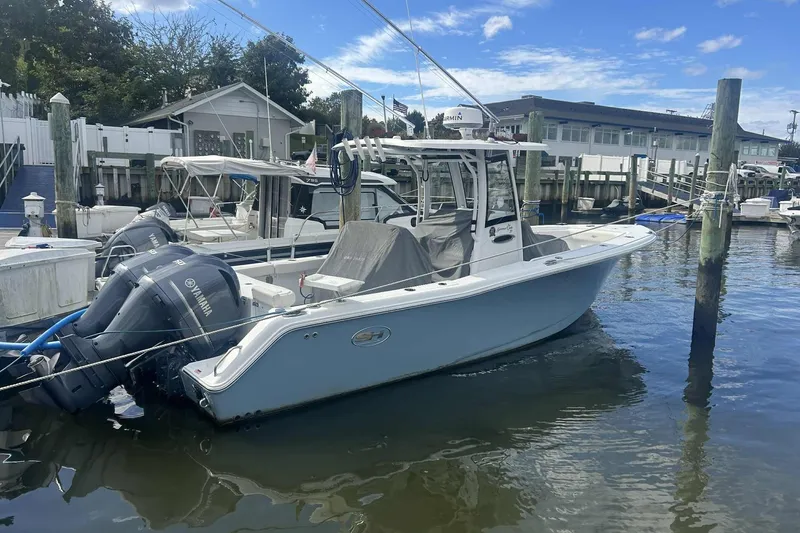 Slide: The Image of 2021 Sea Hunt Gamefish 27 Coffin Box boat docked at marina with Yamaha engines. - 2