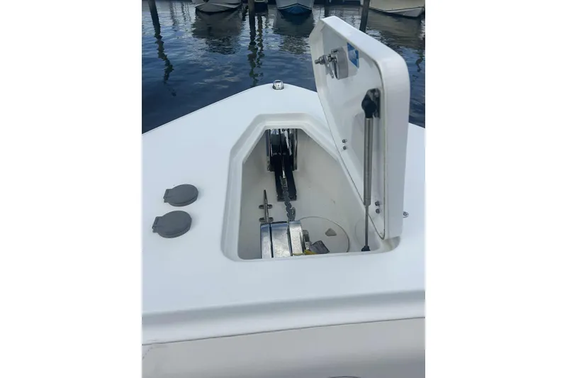 Slide: The Image of Open anchor compartment on 2021 Sea Hunt Gamefish 27 Coffin Box boat, docked by water. - 23