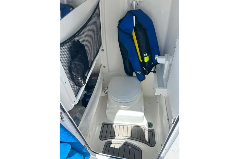 Slide: The Image of Open anchor compartment on 2021 Sea Hunt Gamefish 27 Coffin Box boat, docked by water. - 27