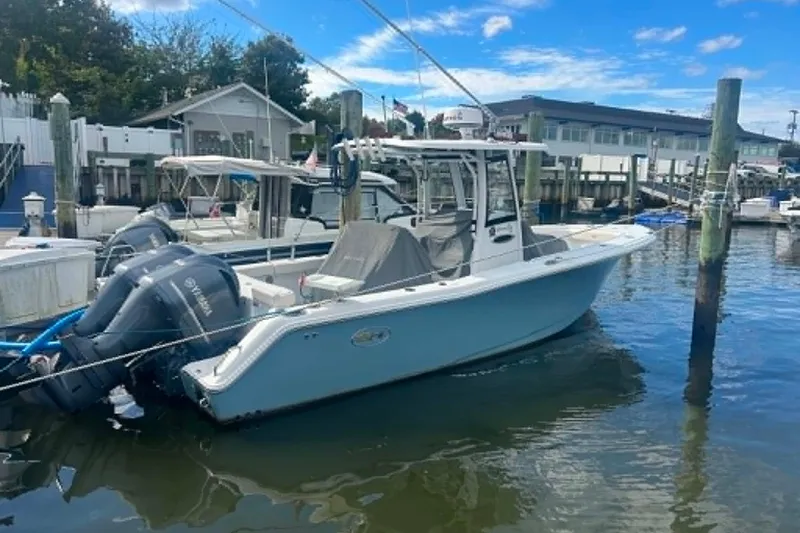 Slide: The Image of 2021 Sea Hunt Gamefish 27 Coffin Box boat docked at marina under blue sky. - 29