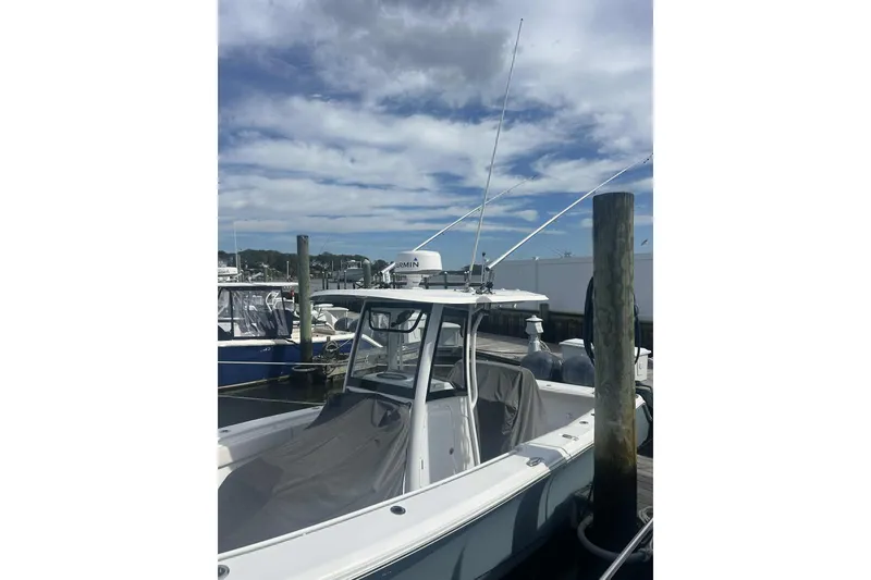 Slide: The Image of 2021 Sea Hunt Gamefish 27 Coffin Box boat docked under a cloudy sky. - 4