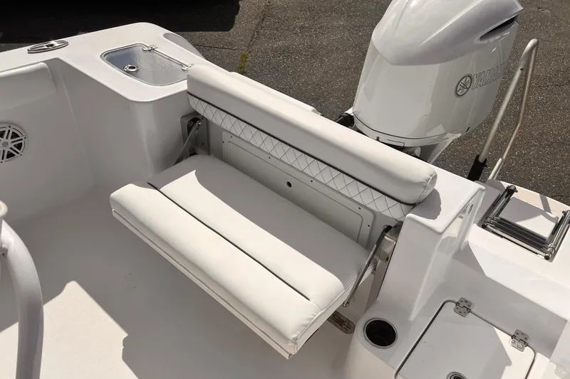 Slide: The Image of 2024 Sportsman Open 242 Center Console boat with white cushioned seating and Yamaha engine. - 5