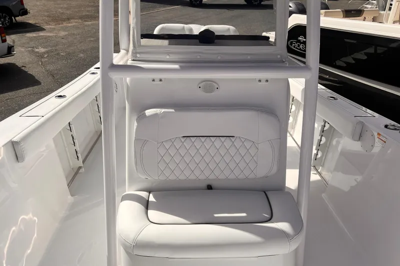 Slide: The Image of 2024 Sportsman Open 242 Center Console boat interior with white cushioned seating. - 9