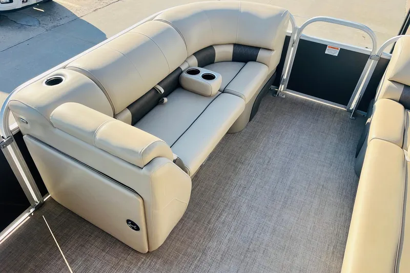 Slide: The Image of 2022 Sun Tracker Party Barge 20 DLX interior with beige seating and cup holders. - 11
