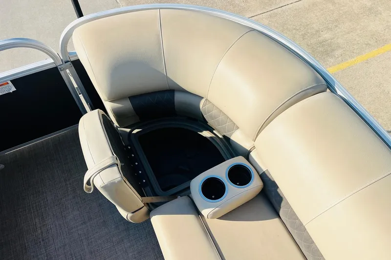 Slide: The Image of 2022 Sun Tracker Party Barge 20 DLX interior with beige seating and cup holders. - 18