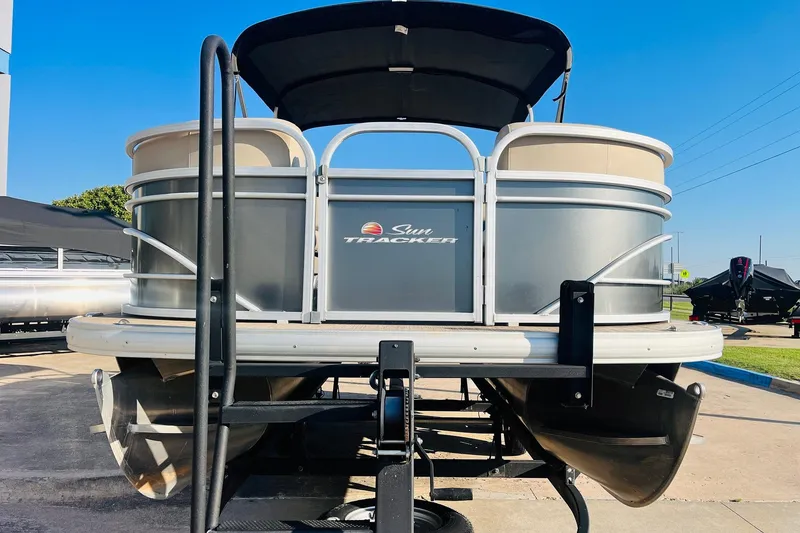Slide: The Image of 2022 Sun Tracker Party Barge 20 DLX pontoon boat, front view, parked outdoors. - 2