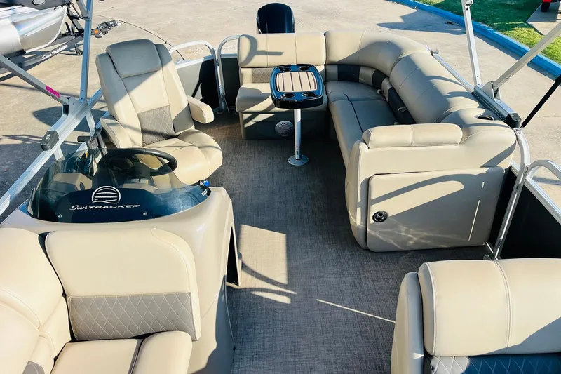 Slide: The Image of 2022 Sun Tracker Party Barge 20 DLX interior with beige seating and table. - 20