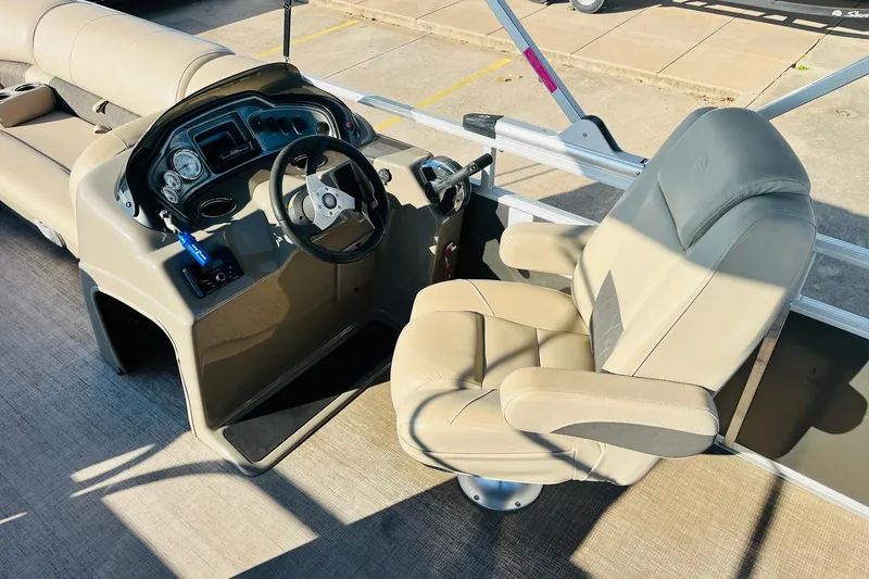Slide: The Image of 2022 Sun Tracker Party Barge 20 DLX helm with beige captain's chair and control panel. - 29