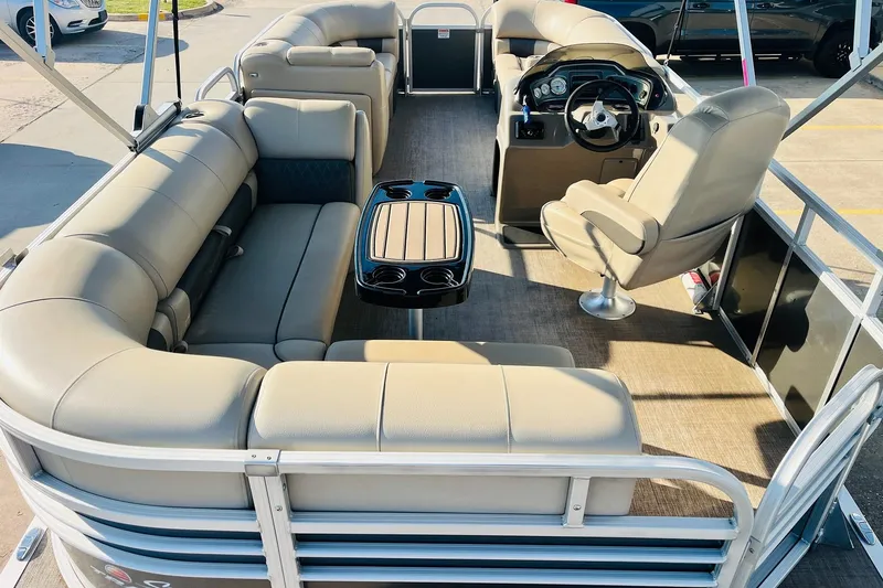 Slide: The Image of 2022 Sun Tracker Party Barge 20 DLX interior with beige seating and steering console. - 9