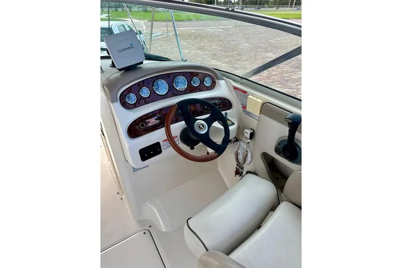 Slide: The Image of 2004 Sea Ray 270 Sundeck helm with Garmin navigation and classic wood-trimmed steering wheel. - 28