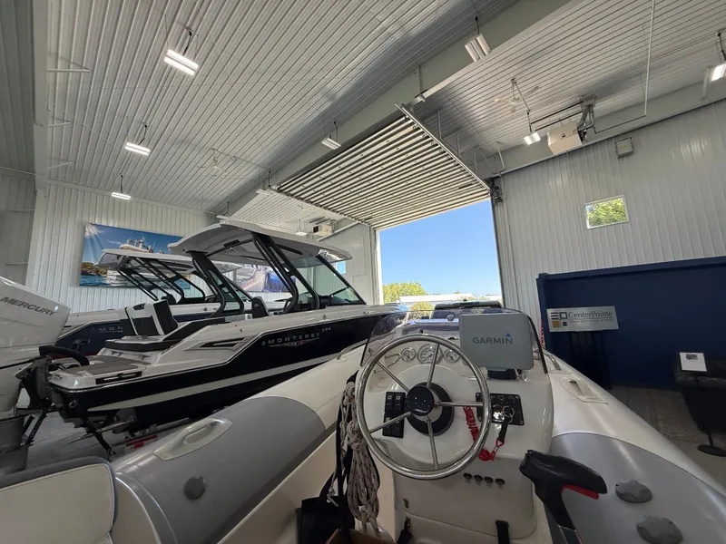 Slide: The Image of Indoor showroom featuring a 2009 Walker Bay Generation 430 boat with Garmin navigation system. - 4