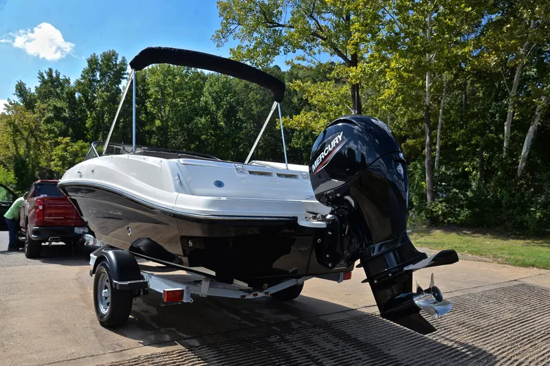 Slide: The Image of 2018 Bayliner VR5 Bowrider OB on trailer, parked near trees and a red truck. - 12