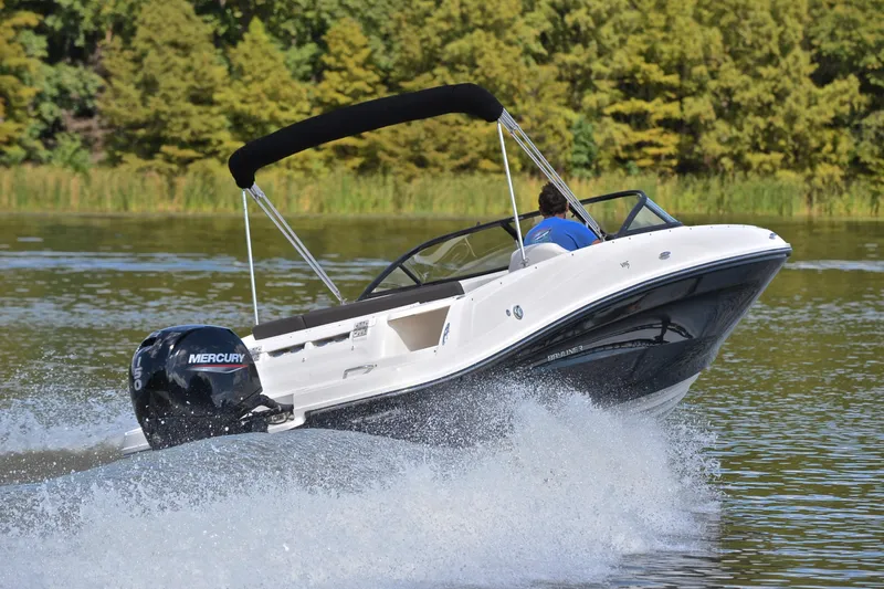 Slide: The Image of 2018 Bayliner VR5 Bowrider OB speeding on a lake with lush green background. - 5