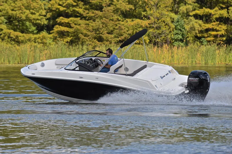 Slide: The Image of 2018 Bayliner VR5 Bowrider OB speeding on a lake with lush greenery background. - 6