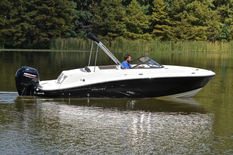 Slide: The Image of 2018 Bayliner VR5 Bowrider OB cruising on a serene lake with lush greenery. - 7