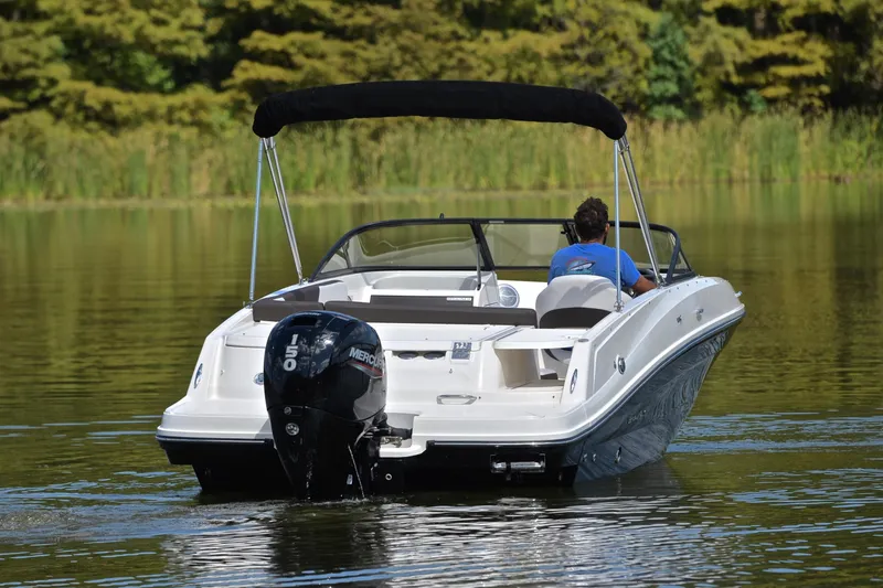 Slide: The Image of 2018 Bayliner VR5 Bowrider OB cruising on a calm lake with lush greenery. - 8