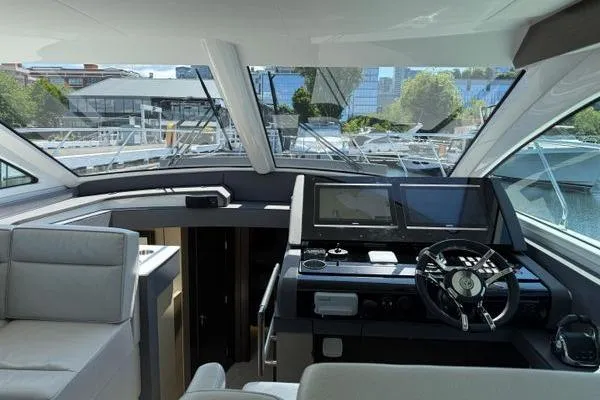 Slide: The Image of 2018 Cruisers Cantius yacht interior with modern helm, navigation screens, and panoramic windows. - 3