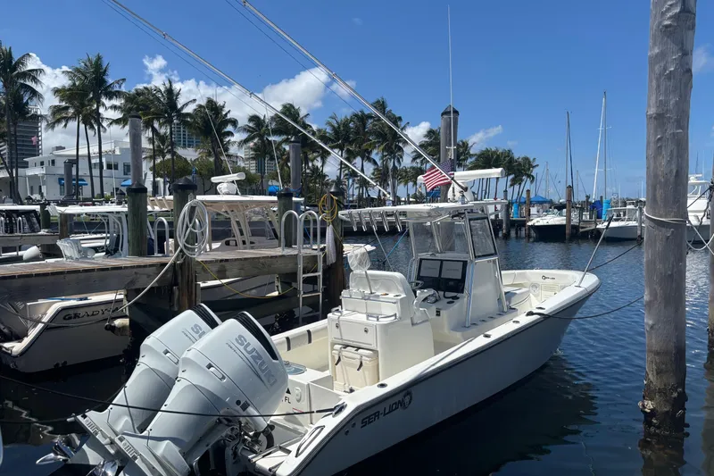Slide: The Image of 2021 Sea-Lion 27 CC boat docked at marina with palm trees and clear sky. - 4