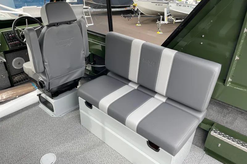 Slide: The Image of 2026 Hewescraft 210 Sea Runner ET HT boat with clear enclosure, parked outdoors. - 12