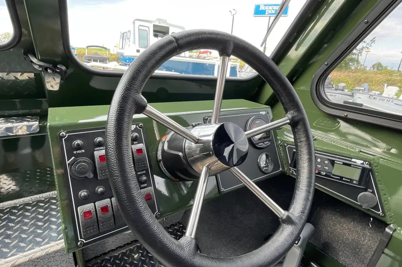 Slide: The Image of Interior of 2026 Hewescraft 210 Sea Runner ET HT boat, featuring green dashboard and window views. - 17