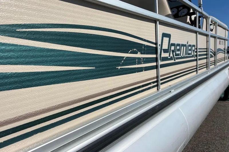 Slide: The Image of 2002 Premier 225 Majestic pontoon boat with teal and beige design details. - 12