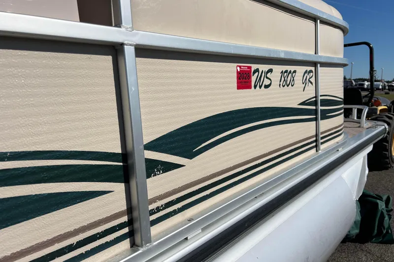 Slide: The Image of 2002 Premier 225 Majestic pontoon boat with registration sticker and green wave design. - 13