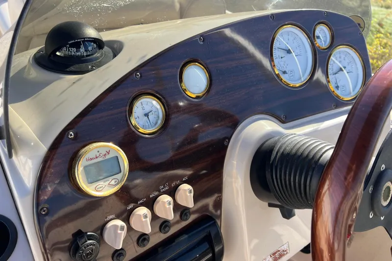 Slide: The Image of 2002 Premier 225 Majestic boat dashboard with gauges, compass, and controls. - 21