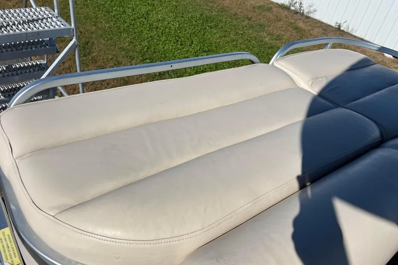 Slide: The Image of Cream leather seating on 2002 Premier 225 Majestic boat, with metal railings and grass background. - 24