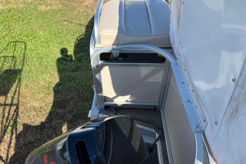 Slide: The Image of 2002 Premier 225 Majestic boat interior with seating and engine, shadow on grass. - 25