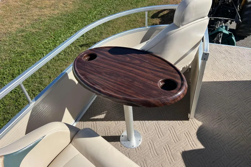 Slide: The Image of Premier 225 Majestic 2002 boat interior with wooden table and cup holders. - 32