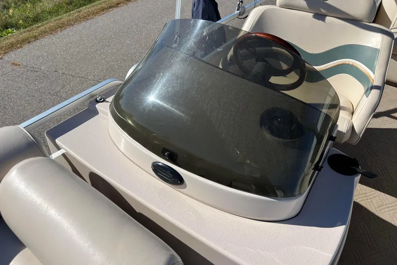 Slide: The Image of 2002 Premier 225 Majestic boat dashboard with steering wheel and windshield. - 33
