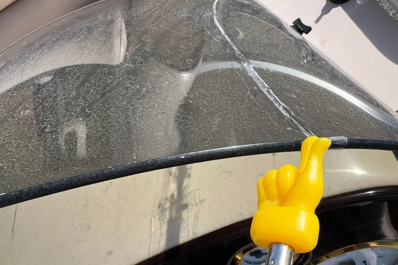 Slide: The Image of Cracked windshield on 2002 Premier 225 Majestic boat with yellow hand-shaped handle. - 34