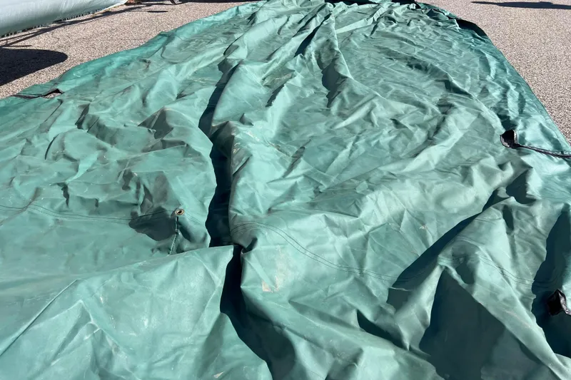 Slide: The Image of Green tarp covering a 2002 Premier 225 Majestic boat on pavement. - 43
