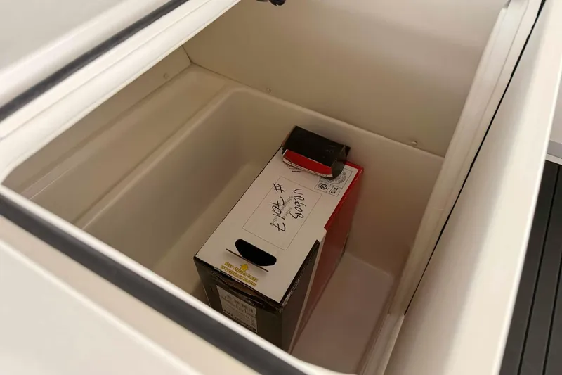 Slide: The Image of Storage compartment in 2026 Bayliner VR6 Bowrider OB boat, containing a boxed item. - 12