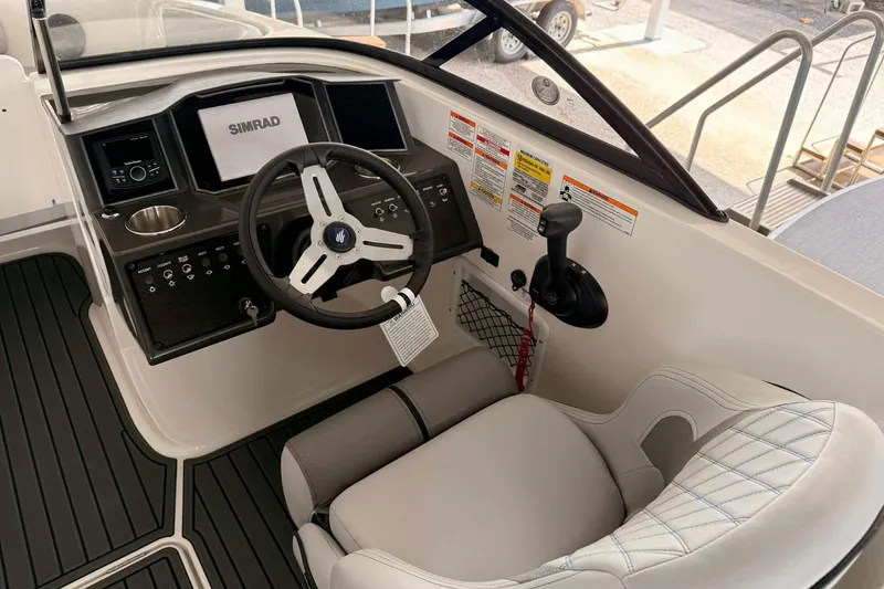 Slide: The Image of 2026 Bayliner VR6 Bowrider OB cockpit with steering wheel, controls, and Simrad display. - 2