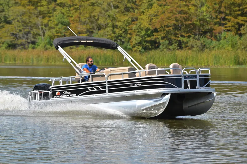 The Image of 2023 Sun Tracker Fishin' Barge 20 DLX cruising on a serene lake. - 1