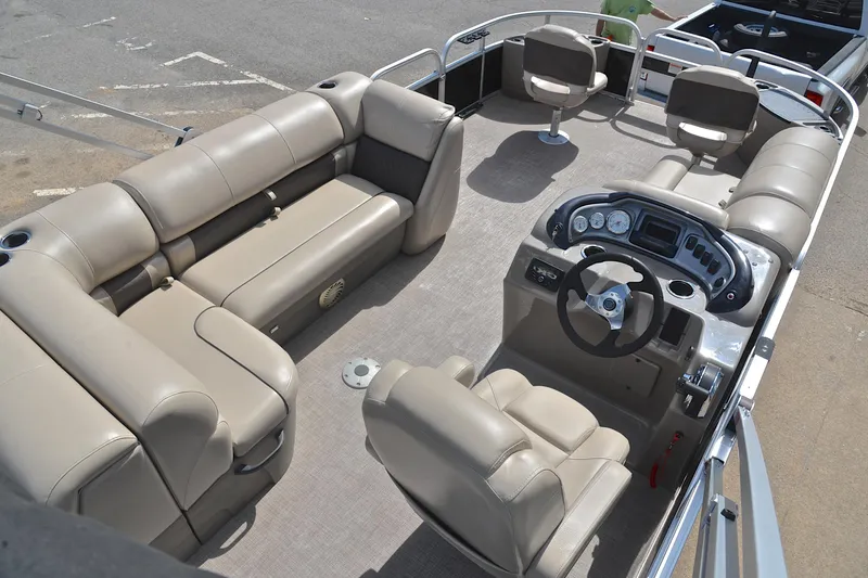 Slide: The Image of 2023 Sun Tracker Fishin' Barge 20 DLX interior with beige seating and steering console. - 19