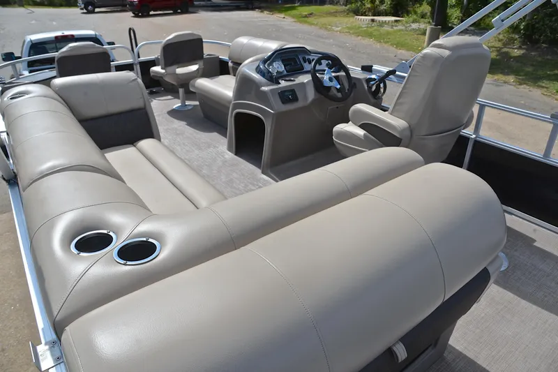 Slide: The Image of 2023 Sun Tracker Fishin' Barge 20 DLX interior with beige seating and steering console. - 24