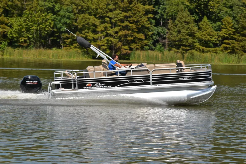 Slide: The Image of 2023 Sun Tracker Fishin' Barge 20 DLX pontoon boat cruising on a lake. - 3