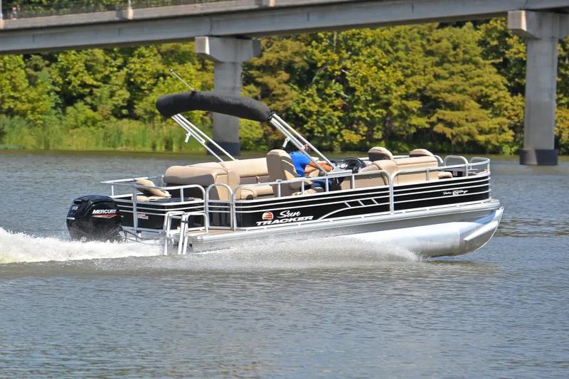 Slide: The Image of 2023 Sun Tracker Fishin' Barge 20 DLX pontoon boat cruising on a river. - 5