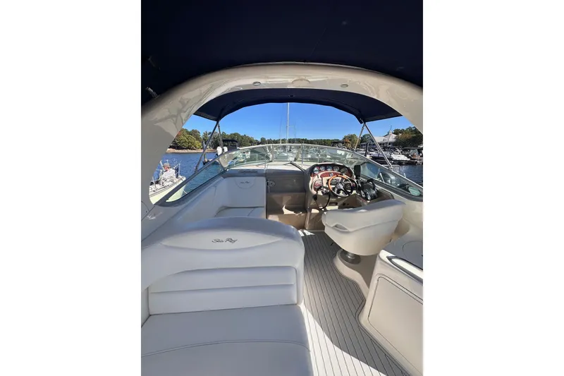 Slide: The Image of 2005 Sea Ray 280 Sundancer boat interior with helm, seating, and canopy on a sunny day. - 13