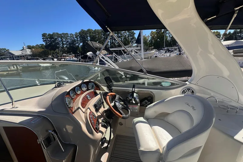 Slide: The Image of 2005 Sea Ray 280 Sundancer cockpit with steering wheel, gauges, and marina view. - 15