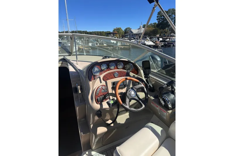 Slide: The Image of 2005 Sea Ray 280 Sundancer helm with gauges and steering wheel, docked at marina. - 16