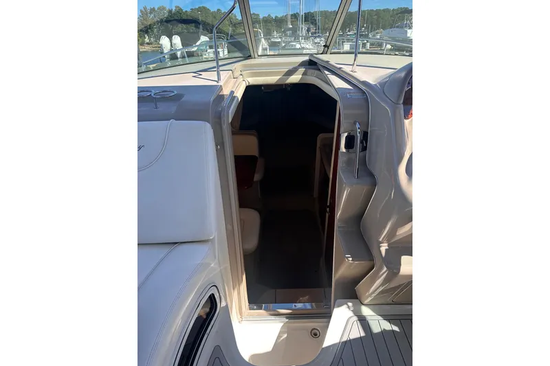 Slide: The Image of 2005 Sea Ray 280 Sundancer cabin entrance with open door, showcasing interior seating. - 20
